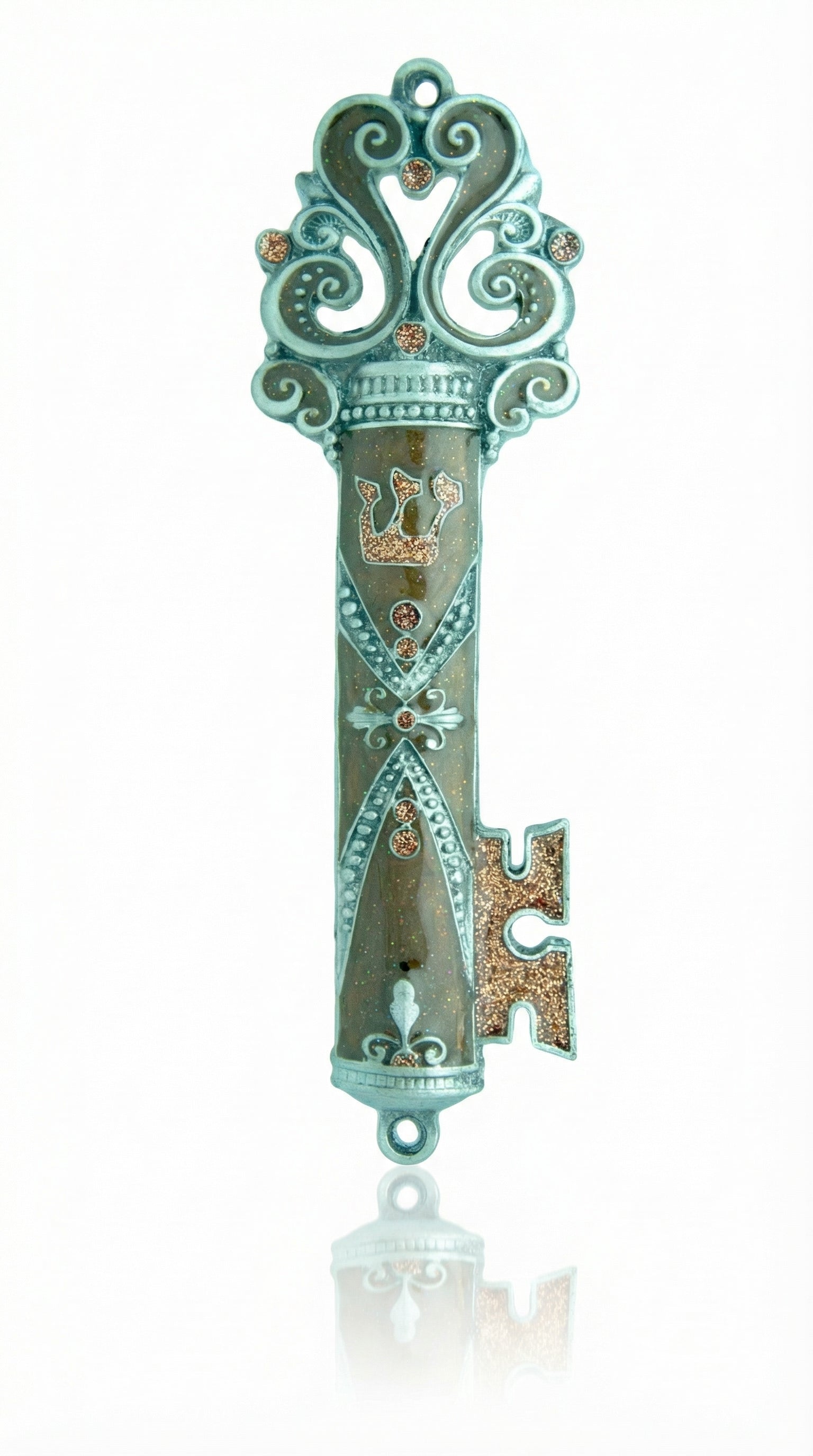 Ornate brown enamel pewter mezuzah in key shape, displayed on a white studio background with soft reflection, detailed craftsmanship.