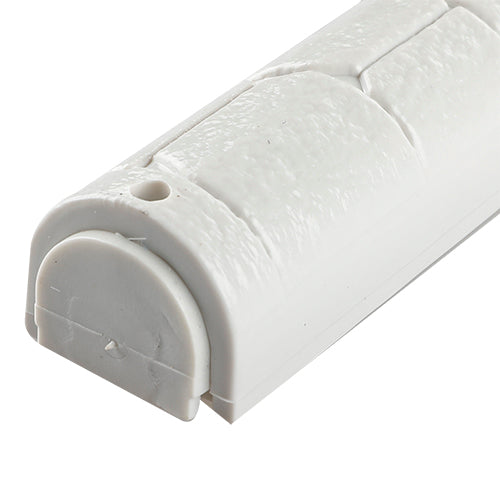 Close view of the bottom closure on the Kotel Stonework Clear Silver Shin mezuzah cover, showing the pale rounded plastic cap, nearby fixing hole and molded stone-block texture around the scroll-insertion end of the case