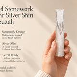 Kotel Stonework Clear Silver Shin Mezuzah mezuzah cover held upright in one hand, showing a clear plastic body, molded stone-block texture and an elongated silver-colored Hebrew Shin above the rounded bottom closure beside the product name and illustrated design features in a wide social-sharing graphic for decorative Jewish home Judaica