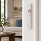 Kotel Stonework Clear Silver Shin Mezuzah mezuzah cover mounted vertically on an interior doorjamb in a portrait view, showing a clear plastic body, molded stone-block texture and an elongated silver-colored Hebrew Shin above the rounded bottom closure and the long narrow form of this Jerusalem-inspired Jewish doorway design