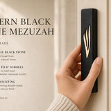 Person holding the exact black stone mezuzah with gold Shin, showcasing its size and design for outdoor or modern home entrances.