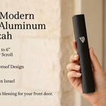 the large black aluminum mezuzah case against a warm interior background, with its silver Hebrew Shin visible beside text about its six-inch kosher scroll fit, waterproof design and Israeli origin