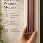 Large Modern Burgundy Pyramid Mezuzah held beside a doorpost, with the muted burgundy wine-red aluminum mezuzah cover shown close enough to reveal its three stepped bars and rounded lower edge alongside product-name and design callouts for this contemporary Judaica piece