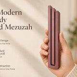 Large Modern Burgundy Pyramid Mezuzah pictured in hand as a muted burgundy wine-red aluminum mezuzah cover with three graduated bars and a contemporary stepped design, alongside its name and illustrated product features in a wide social-sharing image