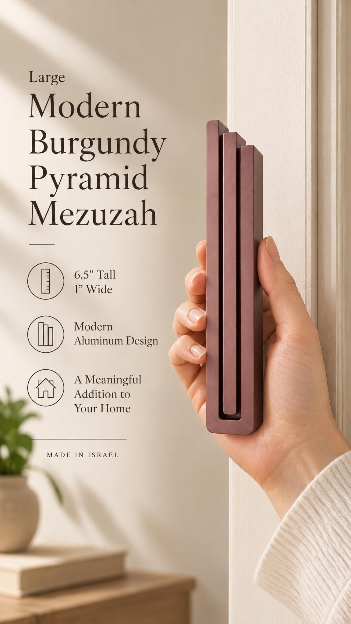 Hand holding the Large Modern Burgundy Pyramid Mezuzah upright, revealing its muted burgundy wine-red aluminum mezuzah cover, slender three-bar Pyramid design and graduated top beside illustrated product features for contemporary Jewish home Judaica