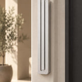 Large Modern Silver Pyramid Mezuzah mounted on a pale doorpost beside its product name and illustrated design features, showing the softly brushed silver aluminum mezuzah cover and three stepped bars as a contemporary detail for a Jewish home entrance