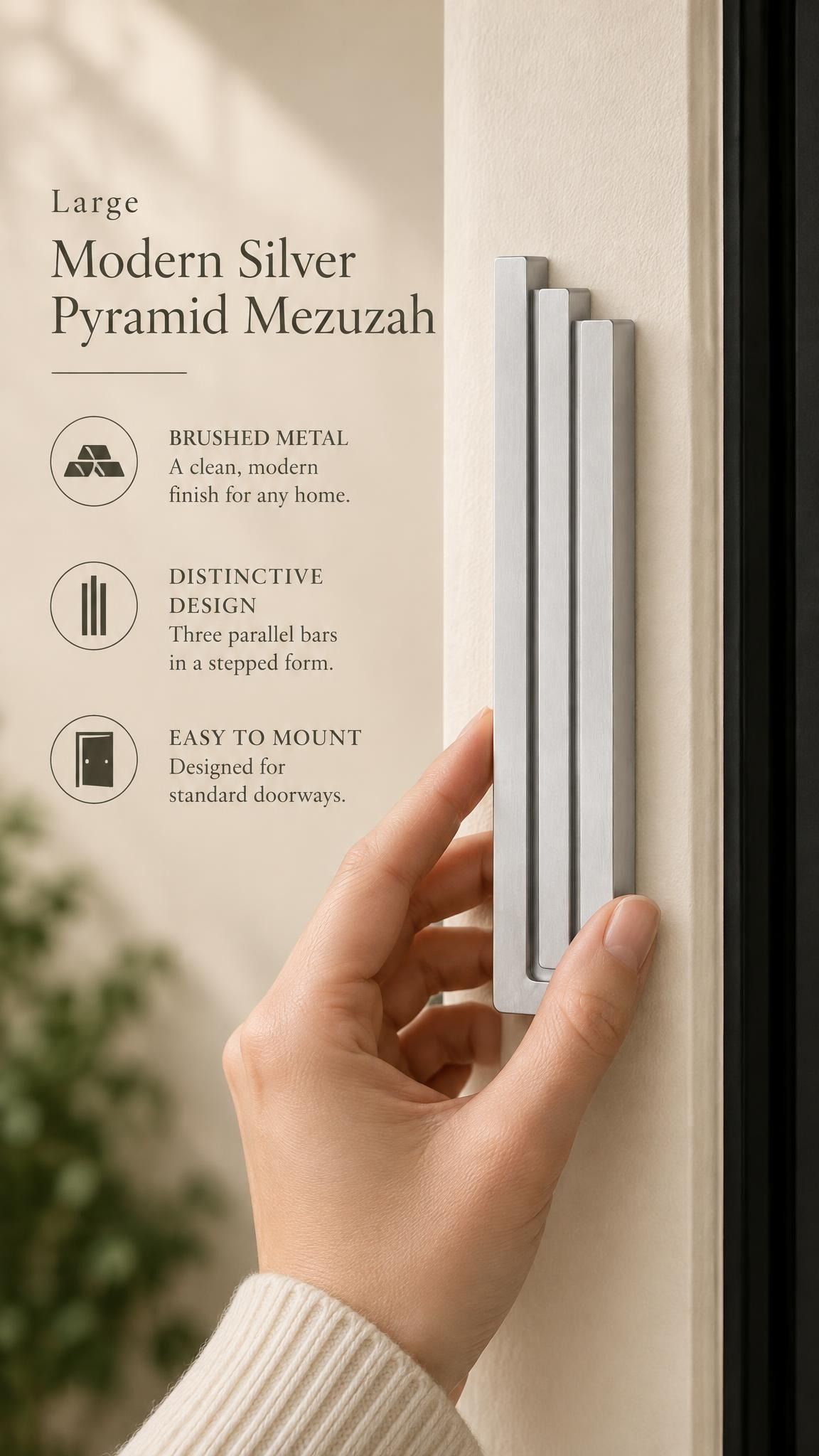 Large Modern Silver Pyramid Mezuzah held beside a doorpost, with the softly brushed silver aluminum mezuzah cover shown close enough to reveal its three stepped bars and rounded lower edge alongside product-name and design callouts for this contemporary Judaica piece