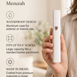 holding the large modern white aluminum outdoor mezuzah case indoors, showing its raised Hebrew Shin beside graphic callouts for waterproof use, a scroll up to six inches and Israeli origin