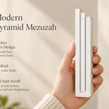 Large Modern White Pyramid Mezuzah pictured in hand as a smooth matte white aluminum mezuzah cover with three graduated bars and a minimalist stepped design, alongside its name and illustrated product features in a wide social-sharing image