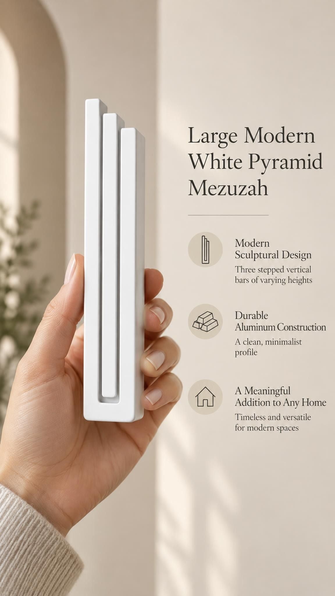 Hand holding the Large Modern White Pyramid Mezuzah upright, revealing its smooth matte white aluminum mezuzah cover, slender three-bar Pyramid design and graduated top beside illustrated product features for minimalist Jewish home Judaica
