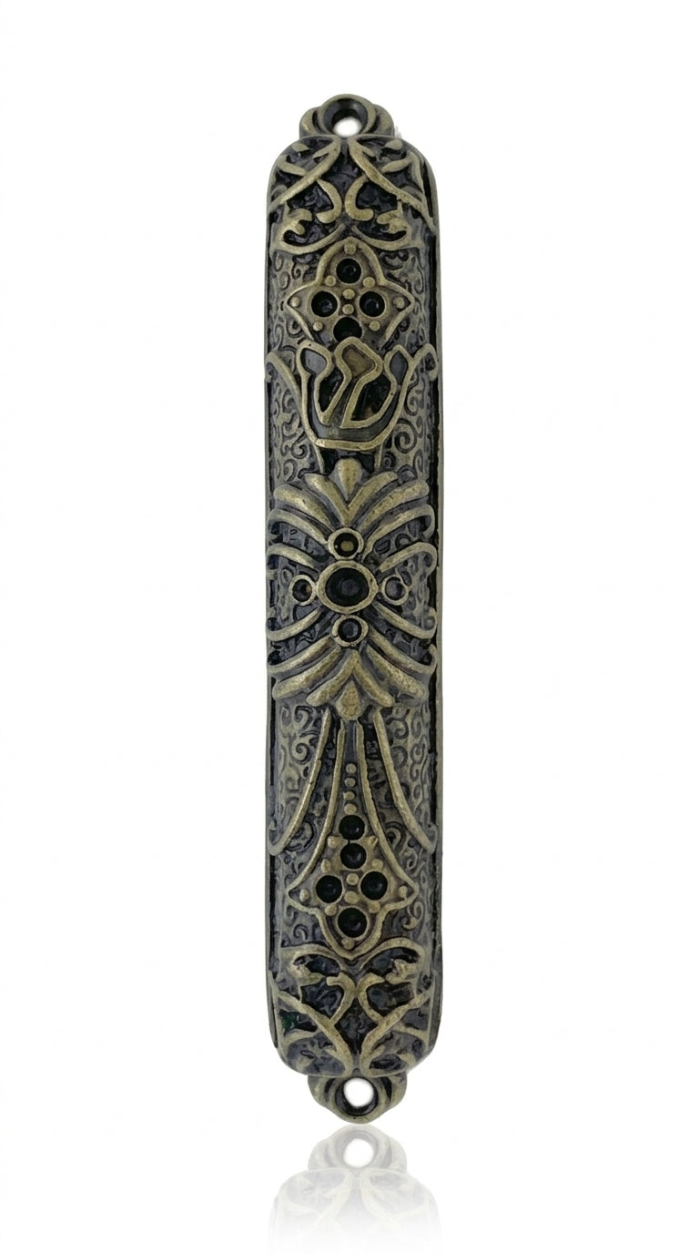 Upscale Levi Mezuzah made of brass, 4 inches tall, with detailed engraved Hebrew lettering and decorative motifs, placed on a white studio background with soft reflection.