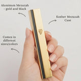 Luxurious gold and black aluminum mezuzah mounted on a modern home door for religious tradition.