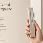 Hand-holding the exact Modern Capital Shin Champagne Mezuzah, highlighting its design and materials in a natural setting for e-commerce.