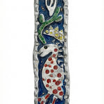Upscale image of a Marc Chagall style Mezuzah with intricate Hebrew engravings, detailed motifs, on a bright white studio surface with light reflection.