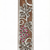 Mahogany Mezuzah with curling pewter vine and maroon stones depicting the holy land, shown on a white background with soft reflection.