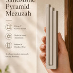 Elegant 9:16 scene of person holding the sandstone pyramid mezuzah with editorial text nearby in a neutral setting.