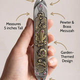 Clean callout image of a person holding a Garden Jewel Pewter Mezuzah, emphasizing its design and material details.