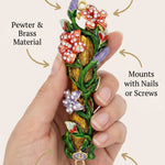 Person holding the colorful flowers mezuzah in a subtle, minimalist style with focus on product details.