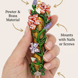 Person holding the colorful flowers mezuzah in a subtle, minimalist style with focus on product details.