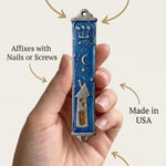 Person holding the pewter mezuzah in a natural pose, highlighting material, size, and traditional design details.