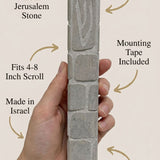 Clean callout image of a person holding the Jerusalem stone mezuzah, showcasing material and craftsmanship subtly and stylishly.