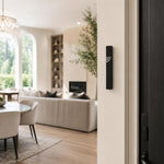 Minimalist Wave black aluminum mezuzah cover mounted on a modern doorpost with a waterproof profile and curved silver Shin detail