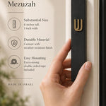 Timeless black cement mezuzah case made in Israel with a raised gold Shin, narrow six-inch profile, and clean contemporary design mounted on a doorpost
