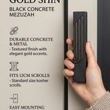 A hand holds a modern black concrete mezuzah case featuring a raised embossed Hebrew Shin with elegant gold trim.