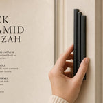 Person holding the black aluminum pyramid mezuzah cover on a doorpost