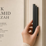 Person holding the black aluminum pyramid mezuzah cover on a doorpost