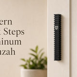 Modern Black Steps waterproof aluminum mezuzah case mounted vertically on a light-colored doorpost, featuring layered architectural black fins and a contrasting silver Hebrew Shin, made in Israel for modern indoor and outdoor Jewish doorways