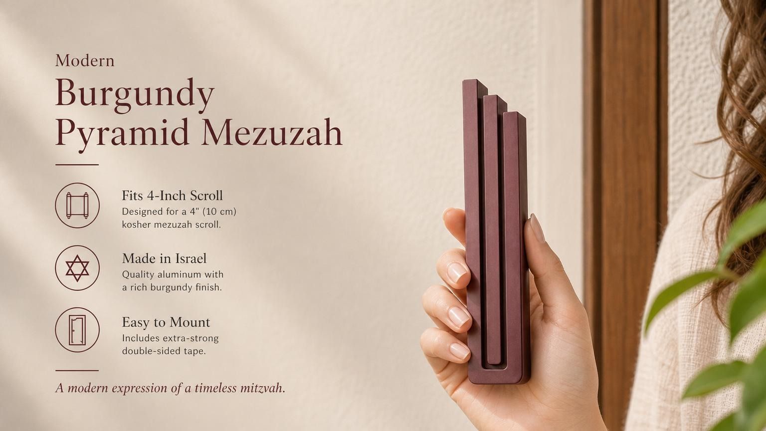 Person holding the Modern Burgundy Pyramid Mezuzah, made of aluminum with a deep red finish, showcasing its architectural stepped design
