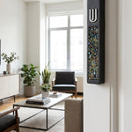 Hyper-realistic scene of a modern cement mezuzah with colorful stone inlay mounted on a narrow interior doorway on the right side, in a stylish home interior.