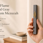 the Eternal Flame Charcoal Gray Aluminum Mezuzah, showing the dark gray mezuzah case with a raised gold ner tamid and stylized Shin on a doorway, with Made in Israel, waterproof outdoor use, and 5-inch kosher scroll fit highlighted