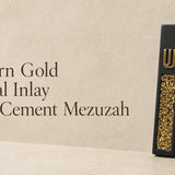 Modern matte black cement mezuzah case featuring a gold crystal and glass inlay with a raised gold Hebrew Shin letter.