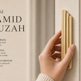 Hand holds the Modern Gold Pyramid Mezuzah, showcasing its architectural design and slim gold profile