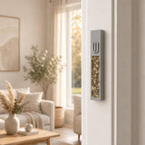 Modern Golden Amber Crystal Inlay Gray Cement Mezuzah mounted vertically on a residential doorpost, showing its raised silver-tone Shin, warm amber crystal and glass inlay, and slim gray cement body in a bright neutral home interior