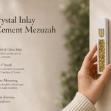 Handheld close view of a modern white cement mezuzah case with a raised gold Hebrew Shin and luminous golden crystal and glass inlay, presented with product features in a contemporary home setting to show its scale, finish, and decorative detail