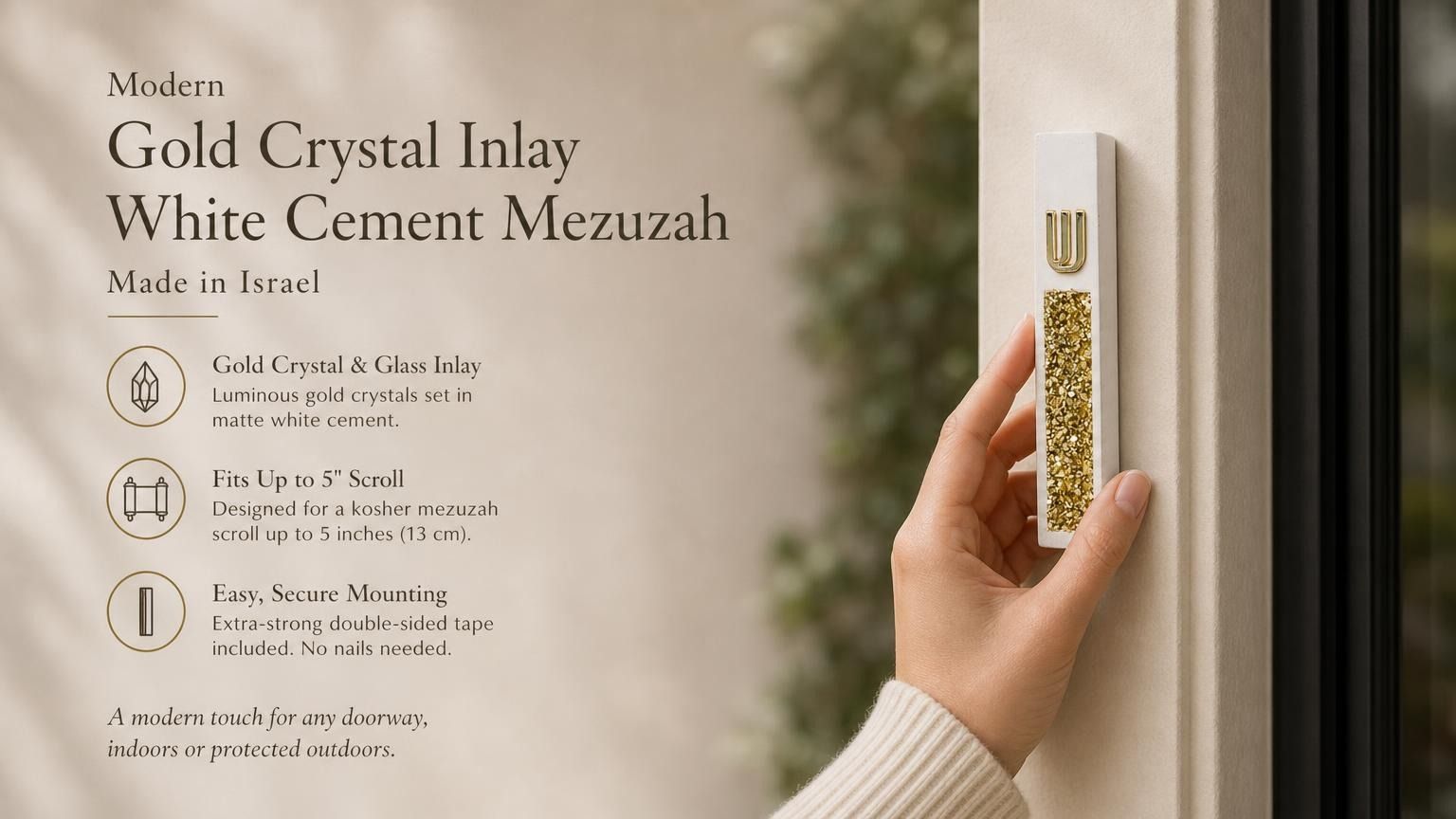 Handheld close view of a modern white cement mezuzah case with a raised gold Hebrew Shin and luminous golden crystal and glass inlay, presented with product features in a contemporary home setting to show its scale, finish, and decorative detail