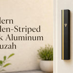 Modern Golden-Striped Black Aluminum mezuzah case mounted on a white doorpost, featuring a sleek matte black rectangular body, narrow vertical gold stripe, and small gold Hebrew Shin. This contemporary black and gold mezuzah case offers a clean minimalist look for modern Jewish homes, front doors, apartments, offices, and interior doorways