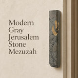 Premium image of a handcrafted gray Jerusalem stone mezuzah mounted on a wall with negative space for category title