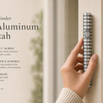 Person holding a gray aluminum mezuzah with polished silver grooves and Hebrew Shin, on a stylish, balanced background with editorial text.