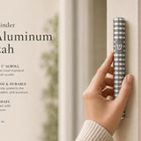 Person holding a gray aluminum mezuzah with polished silver grooves and Hebrew Shin, on a stylish, balanced background with editorial text.
