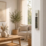 Modern Iridescent Crystal Inlay White Cement Mezuzah mounted vertically on a white residential doorpost, showing the raised silver-tone Shin and reflective multicolor crystal and glass inlay in a bright contemporary Jewish home interior