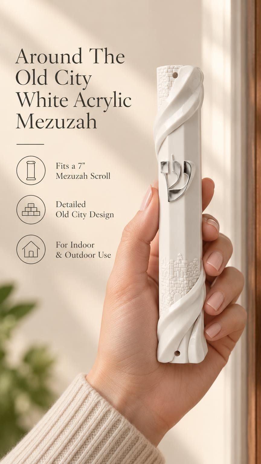 Person holding a white acrylic mezuzah case featuring sculpted Jerusalem wall patterns and a central silver Hebrew Shin letter.