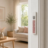Modern Pink Crystal Inlay White Cement Mezuzah mounted vertically on a light residential doorpost, showing the raised silver-tone Shin and sparkling blush and rose crystal inlay in a bright contemporary home or living room doorway