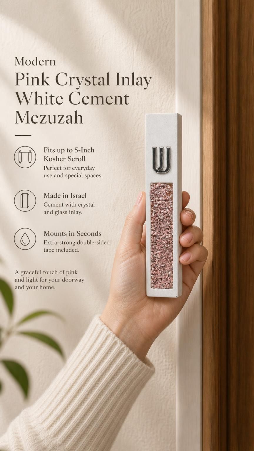 Hand holding a Modern Pink Crystal Inlay White Cement Mezuzah case with a raised silver-tone Shin and sparkling pink, blush, rose, and translucent crystal and glass pieces set into the slim white cement body