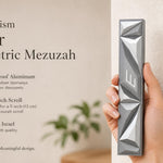Person holding the Cyber Prism Silver Geometric Mezuzah, showcasing its sculpted angular silver panels and Hebrew Shin.