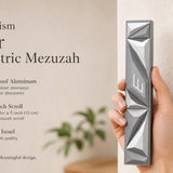 Person holding the Cyber Prism Silver Geometric Mezuzah, showcasing its sculpted angular silver panels and Hebrew Shin.