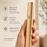 Person holding a modern waterproof gold aluminum outdoor mezuzah, showing its streamlined design and reflective gold finish.